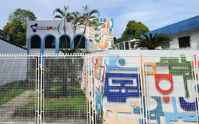 Fotografia ilustrativa da fachada do Check Up Lab, mostrando um padrão colorido de figurtas geométricas na parede.